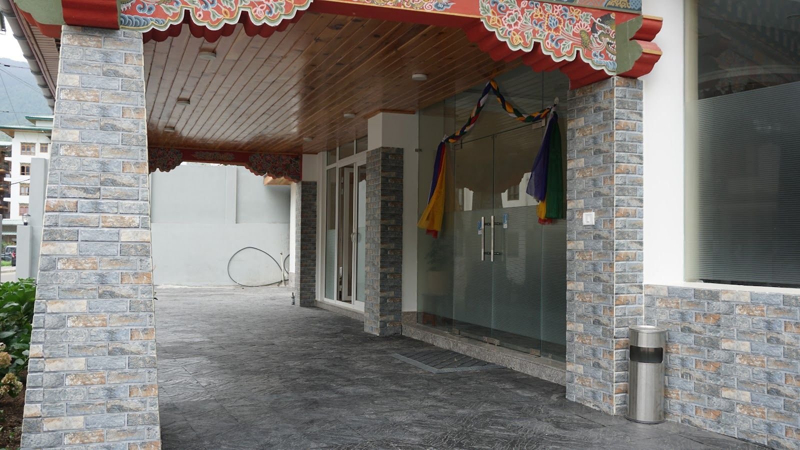 The entrance beneath a carved and painted timber canopy, with stone facing either side of the doors