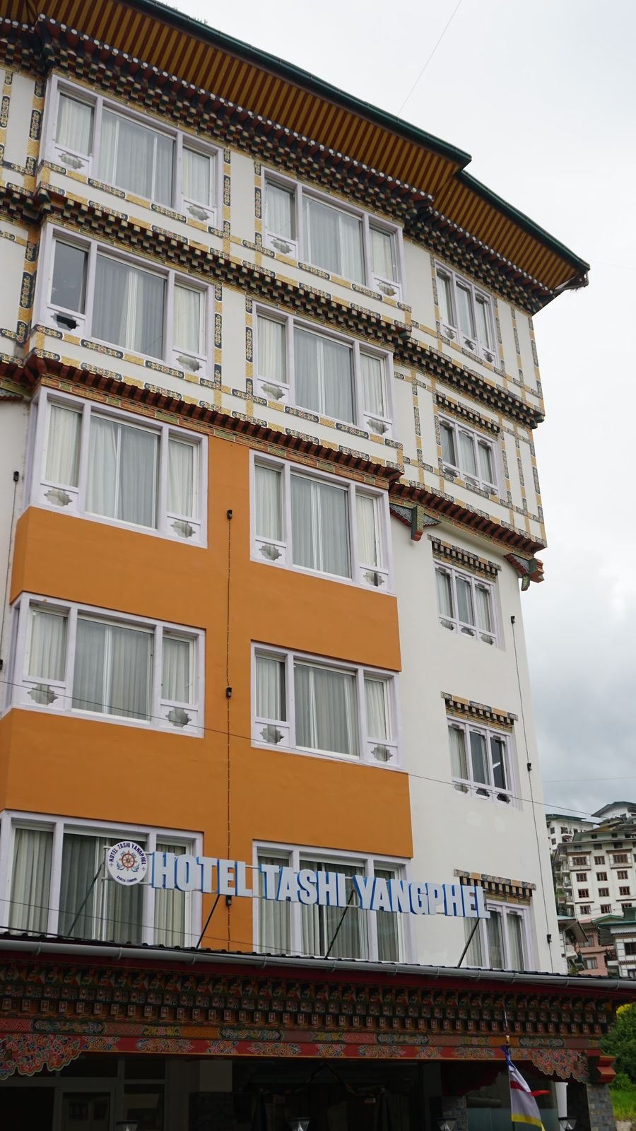 The upper floors seen from below, rows of windows in white surrounds against orange render