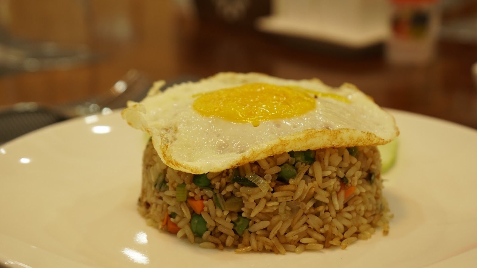 Fried rice pressed into a round, topped with a fried egg and ringed with sliced cucumber