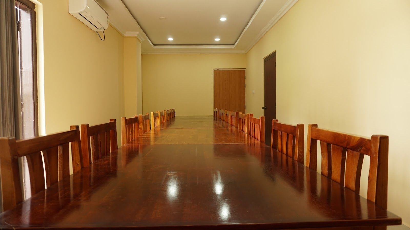 The function room laid out with long polished tables and rows of wooden chairs