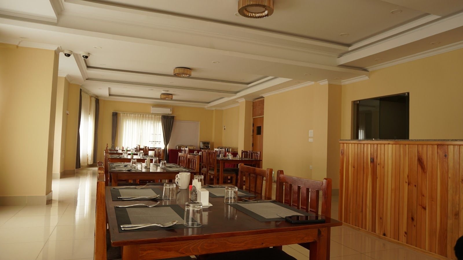 The full width of the dining room, long polished tables and rows of chairs
