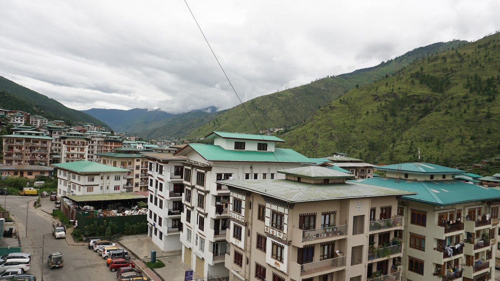 The Thimphu valley from an upper floor, houses stepping up the hillside under cloud